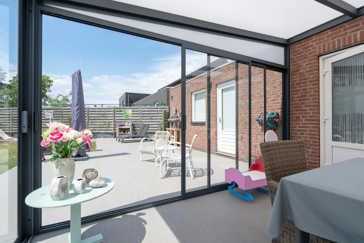 Kaltwintergarten mit Glasschiebesystem als Erweiterung einer Terrassenüberdachung